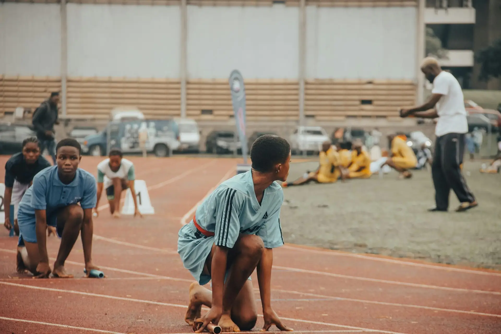 A group of young athletes preparing to race on a track, showing determination and focus.
